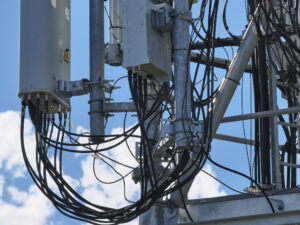 Détail haute résolution du câblage et des connecteurs sur une antenne relais télécom, inspection par drone